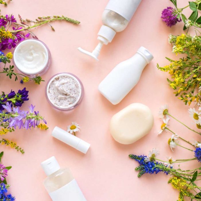 Eco friendly skincare. Natural cosmetics and organic herbs and flowers on pink background, top view, flat lay. Bio research and healthy lifestyle concept.